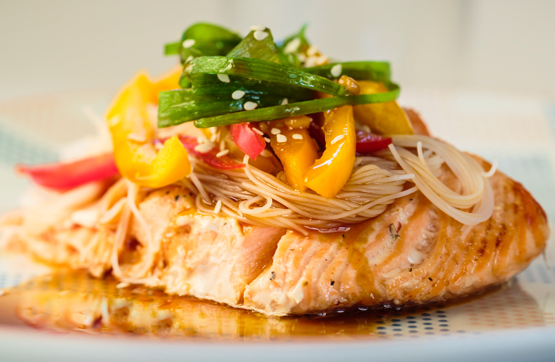 Salmon topped with vermicelli and veggies